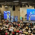 Ландшафтный пейзаж с солнечным закатом над равниной, покрытой цветами и деревьями.